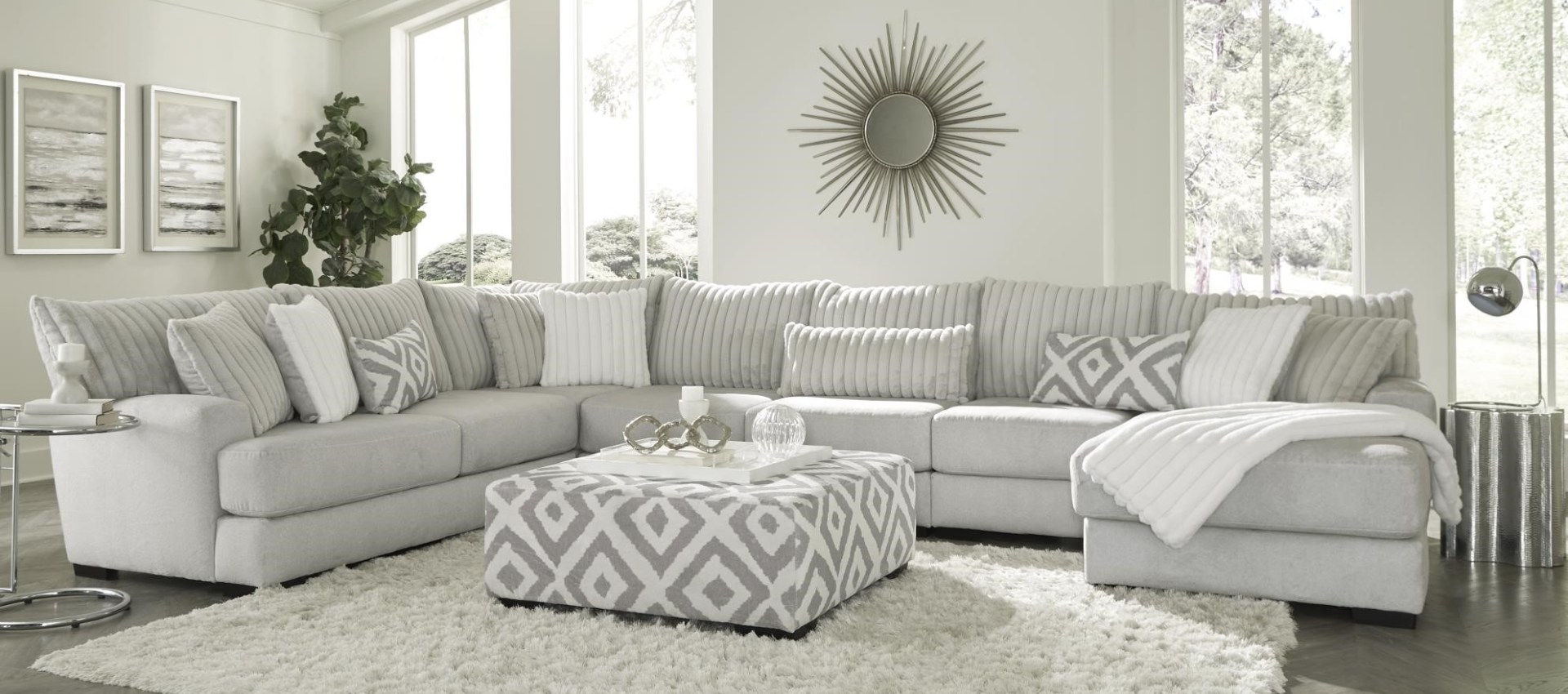 A living room with white furniture and a large window.